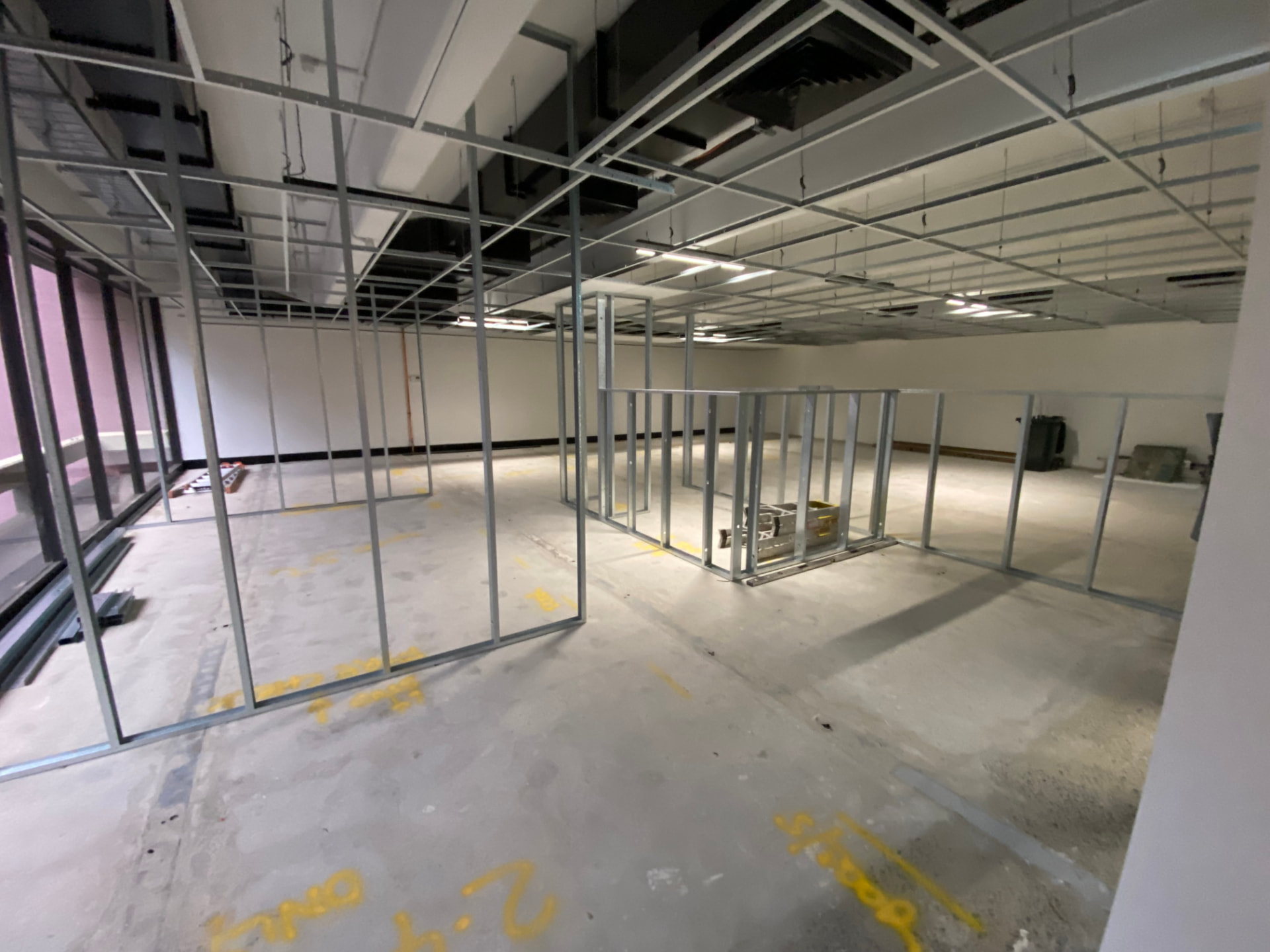 Steel stud partition framing and suspended ceiling grid in a commercial office fit-out